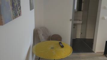 Une pièce avec une table jaune, une chaise et une télécommande posée sur la table.