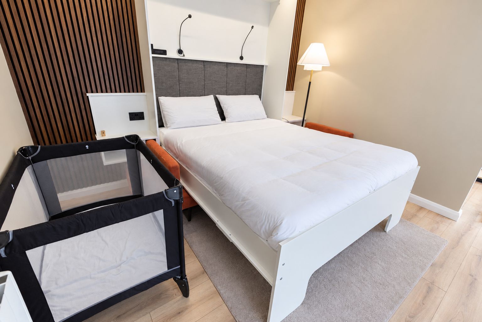 A modern bedroom with a bed, a desk, and a chair.