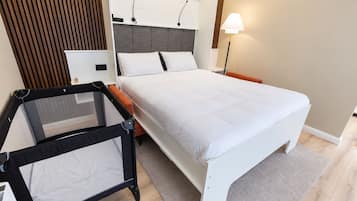 A modern bedroom with a bed, a desk, and a chair.