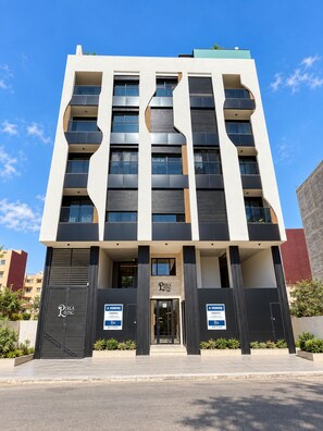 A modern building with a flat facade, large windows, and a prominent entrance. - New Listing (Agadir)