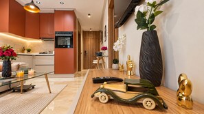 Eine moderne Küche mit Backofen und einer Essecke mit Holztisch und Stühlen.