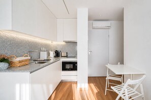 Een moderne keuken met witte kasten, een granieten aanrechtblad en een ingebouwde oven.