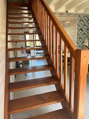 Un escalier en bois avec une rampe, menant à l’étage supérieur.