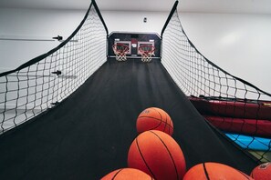 A basketball court with two hoops and a netted enclosure. - The Red Canyon Retreat - Views, Hot Tub, Game Room (Page)
