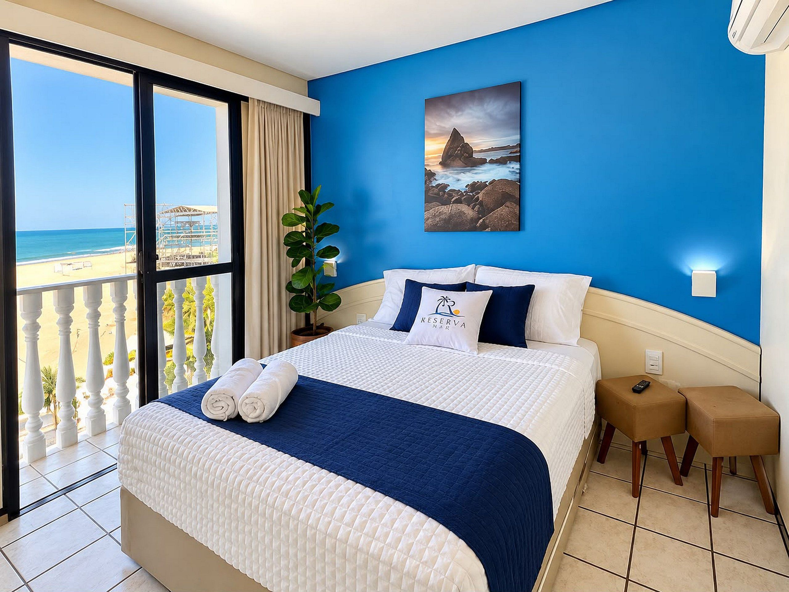 Een hotelkamer met een bed, uitzicht op het strand en een schilderij aan de muur.