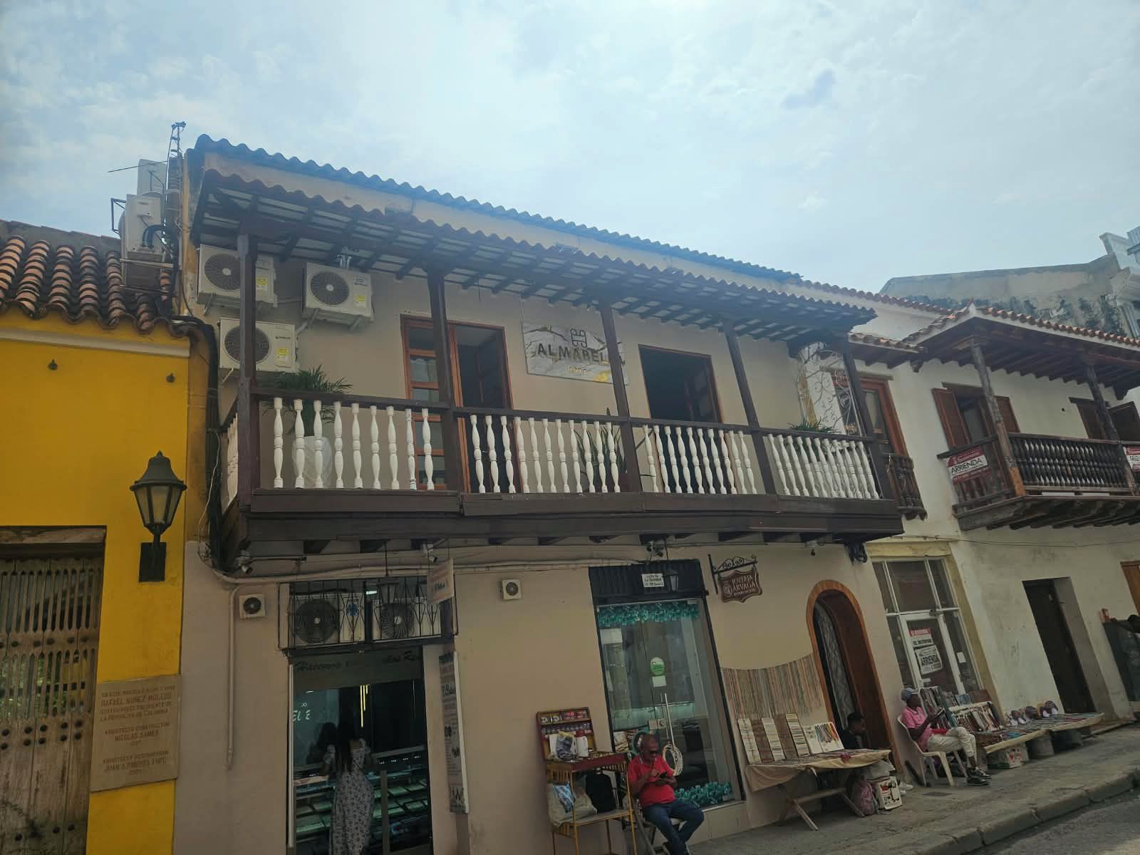 Un immeuble doté d’un balcon, avec un commerce au rez-de-chaussée et une enseigne portant l’inscription « ALMABEL ».