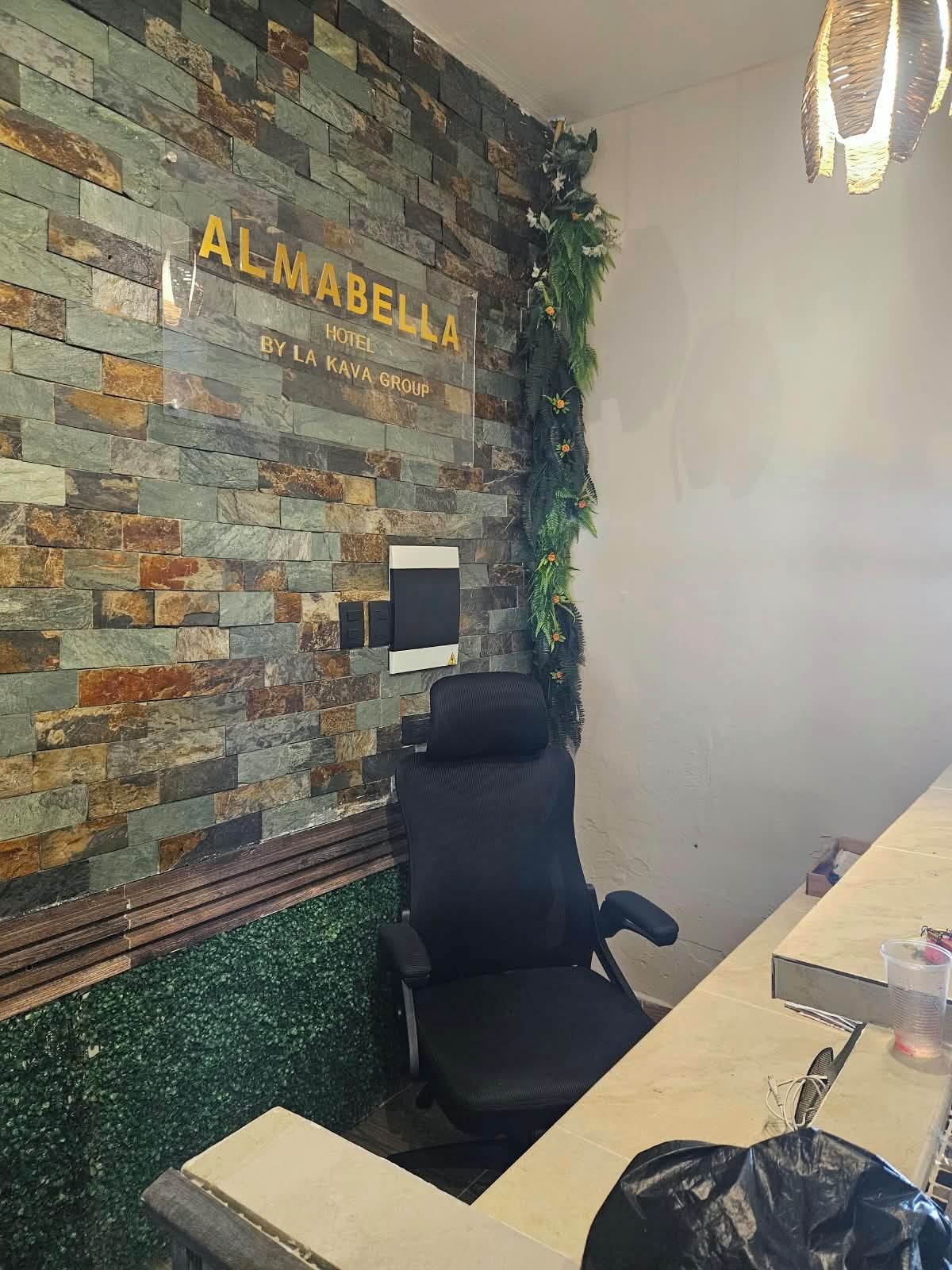 Une salle de conférence avec un mur en pierre, un fauteuil de bureau noir et un bureau doté d’un écran d’ordinateur.