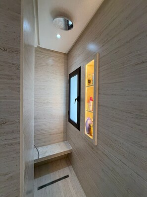 Une salle de bain avec une douche, un miroir et une étagère contenant des articles de toilette.