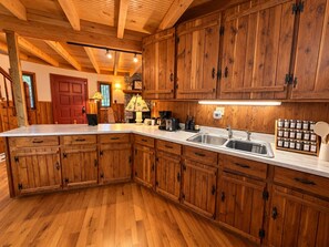 A kitchen with wooden cabinets, a white countertop, and a built-in sink.