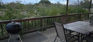 Eine Terrasse mit Grill, Tisch und Stühlen.
