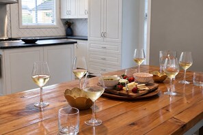 Une table en bois avec des verres à vin et une planche à fromages garnie de fraises et de crackers.