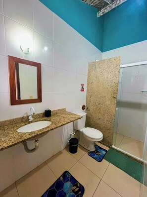 A bathroom with a sink, toilet, and shower area.