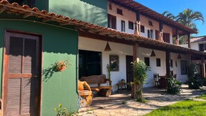 A traditional building with a green facade, wooden shutters, and a tiled roof.