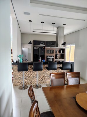 Une cuisine moderne dotée d’un îlot central, de tabourets de bar et d’une table à manger avec des chaises.