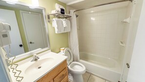Un baño con lavamanos, inodoro y ducha.