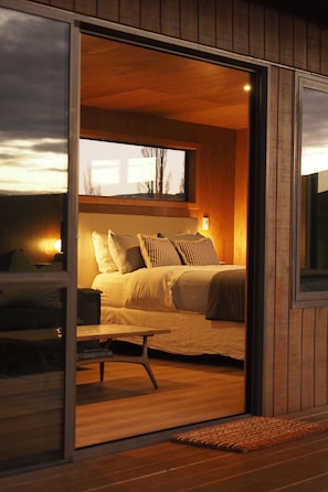 A bedroom with a bed, bedside tables, and a window.