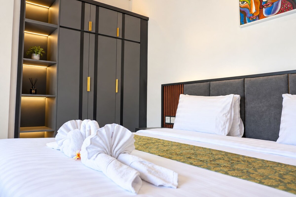 Ein Hotelzimmer mit Bett, Schrank und einem Bild an der Wand.