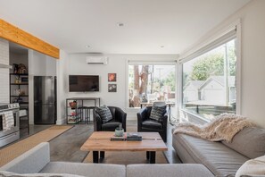 Een moderne woonruimte met een keuken, eethoek en een groot raam.