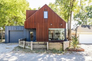 Een modern gelijkvloers huis met een schuin dak, een voortuin en een garage.
