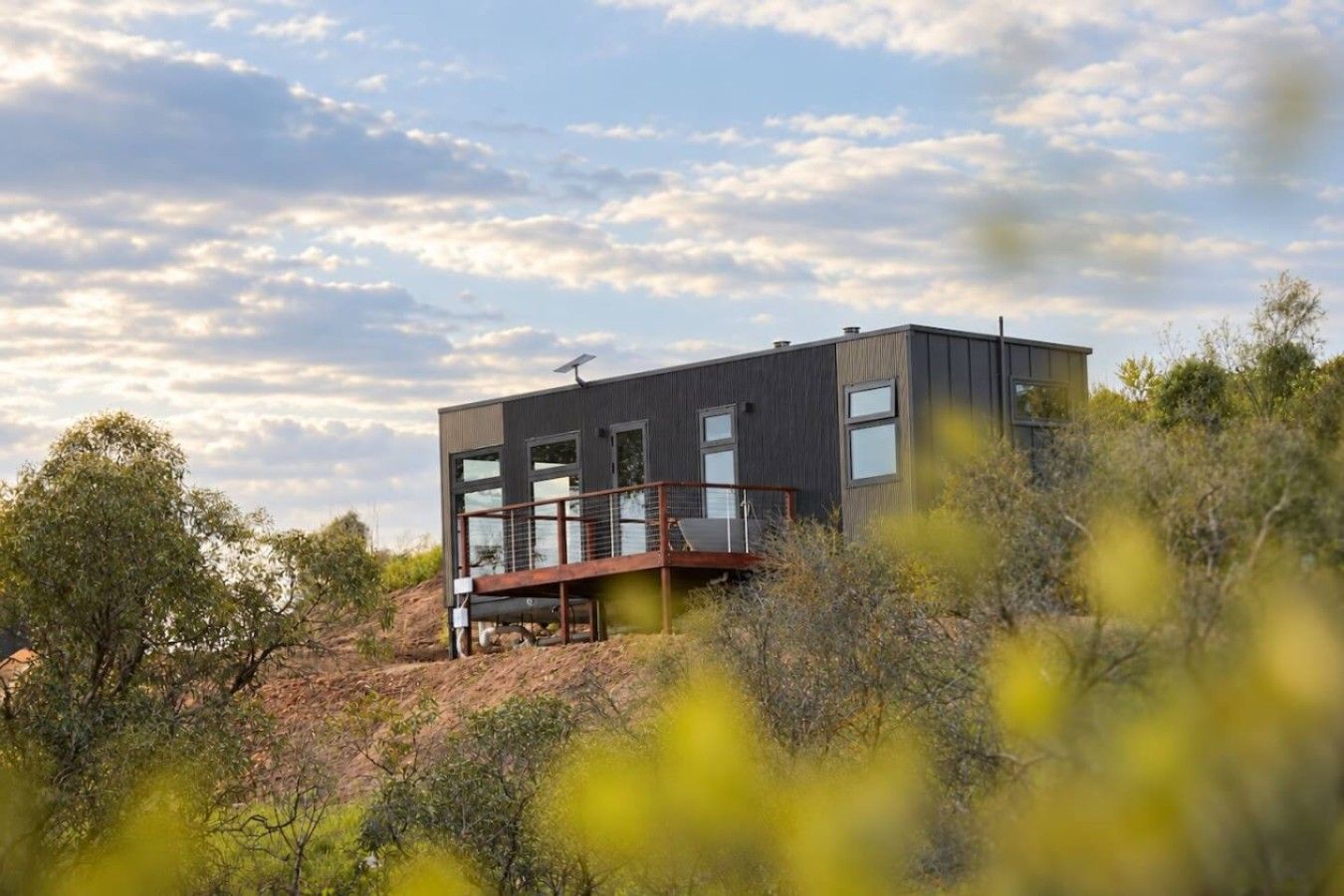 A modern house with a flat roof, large windows, and a deck.