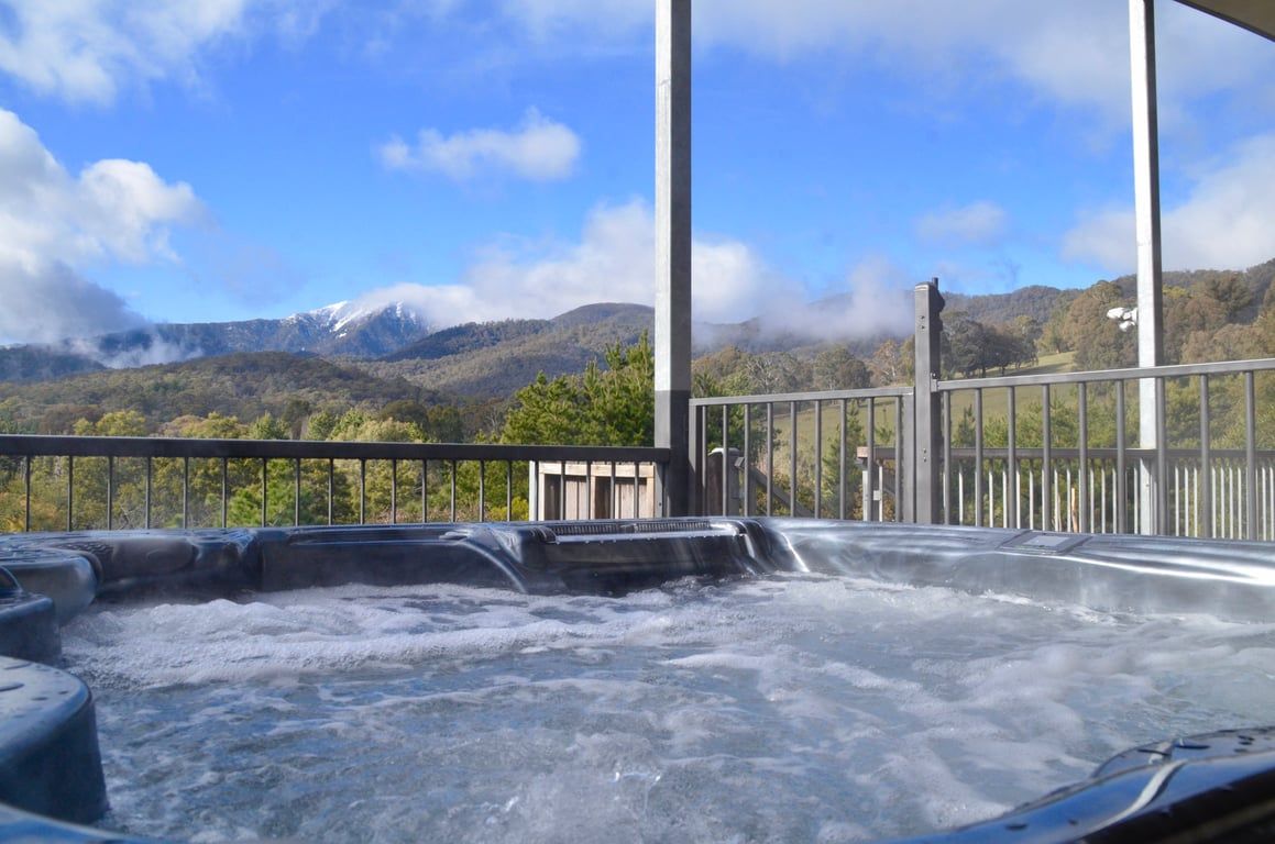 Een hottub met uitzicht op bergen en een heldere lucht.