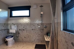 Un bagno con WC, doccia e finestra.