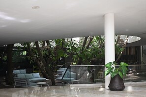 A modern indoor area with seating and a large potted plant. - Alessi's Studio • Coastal Chapter Mactan (Lapu-Lapu)