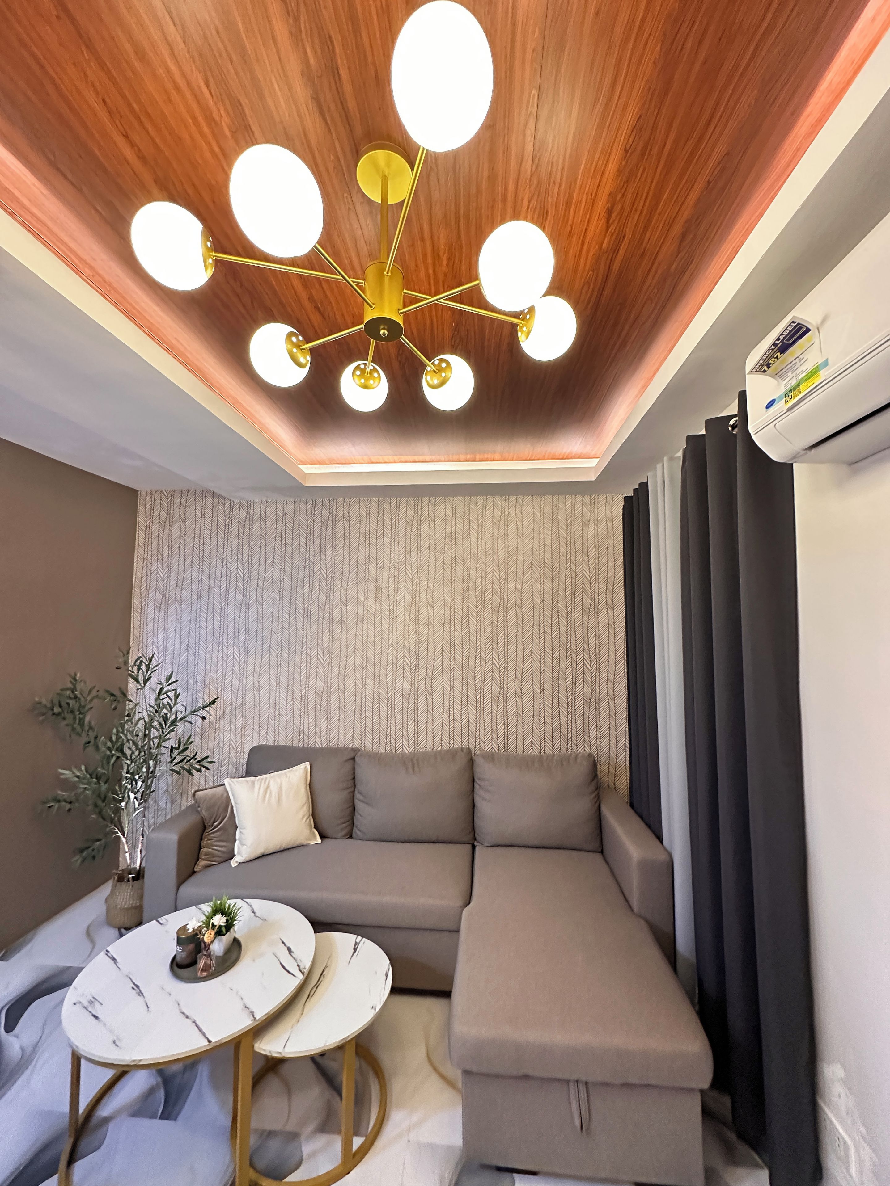 Una sala de estar moderna con un sofá modular, una mesa de centro redonda y una planta decorativa.