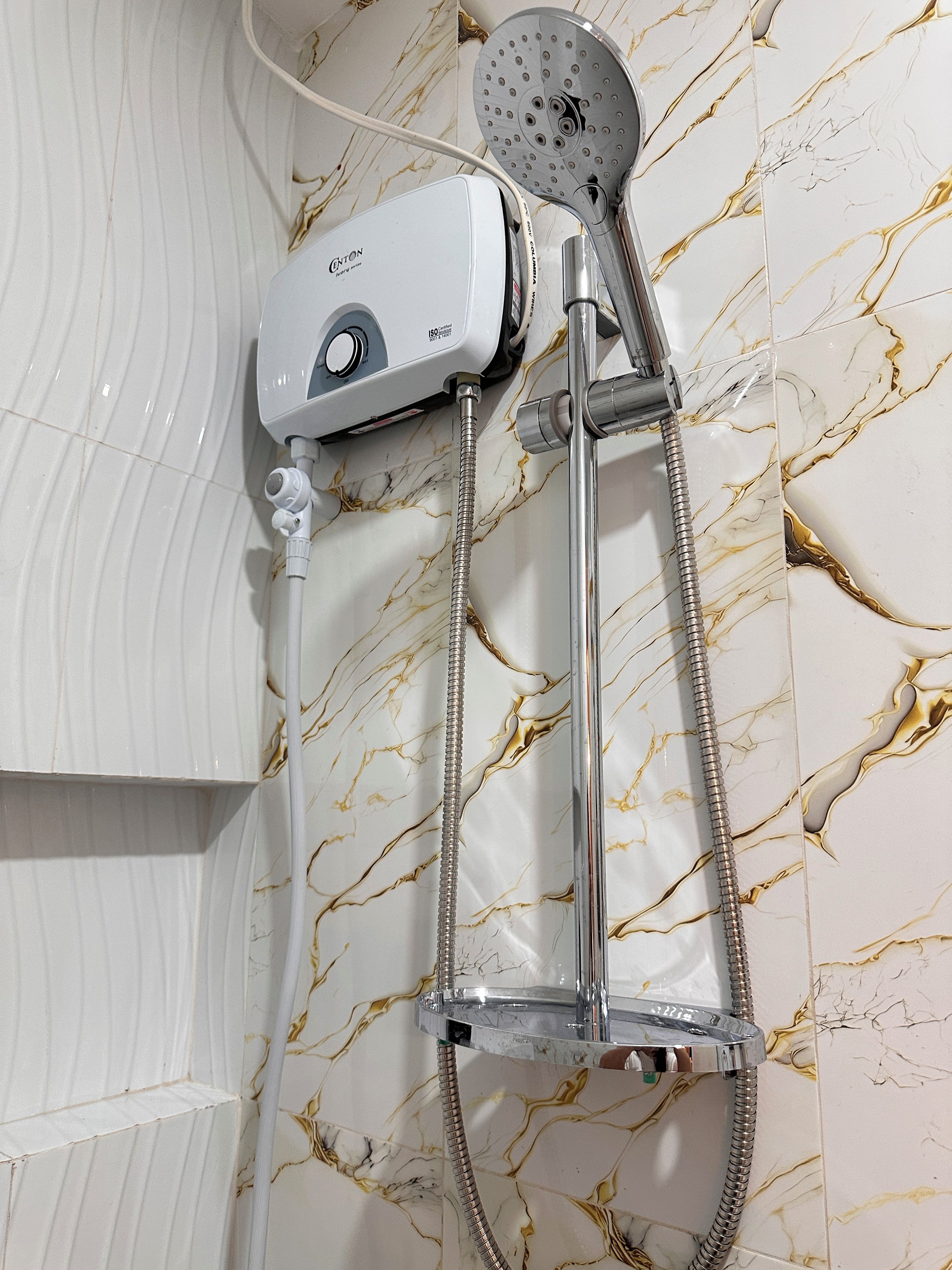 Un baño con cabezal de ducha manual, grifo empotrado y panel de control.