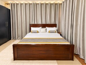 A bedroom with a wooden bed, a dark wardrobe, and grey curtains. - Naguru Rise (Kampala)