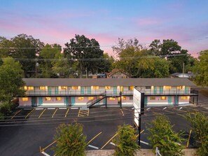 A motel with a two-story structure, a parking lot, and a sign indicating the name and number. - 915 W Main St (Branson)