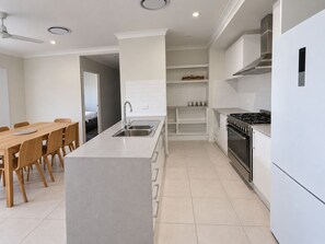 A modern kitchen with a central island, stainless steel appliances, and a dining area with wooden chairs. - The Slow Chapter｜A Park Ridge Retreat (Park Ridge)
