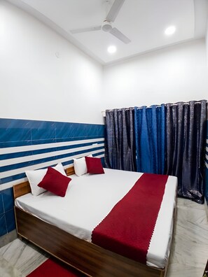 A bedroom with a bed, a ceiling fan, and curtains. - The Kashi Vibe Homestay (Varanasi)