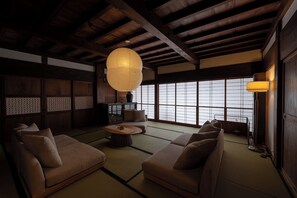 Een traditionele Japanse kamer met tatami vloeren, lage houten meubels en een groot raam met uitzicht.