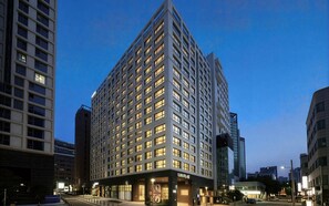 A high-rise hotel with multiple floors, a prominent entrance, and a well-lit facade. - Hotel Comfort, Home Freedom _Studio Double_UH FLAT Seocho New Wing (Seoul)