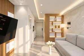 A modern living room with a flat-screen TV, a sofa, a bookshelf, and a vase with flowers. - Hotel Comfort, Home Freedom _Studio Double_UH FLAT Seocho New Wing (Seoul)