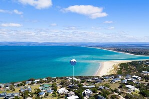 A coastal residential area with houses, a beach, and a clear sky. - The Blue Wren - Freycinet Holiday Houses (Coles Bay)