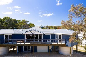 A two-story house with a balcony, large windows, and a garage. - The Blue Wren - Freycinet Holiday Houses (Coles Bay)