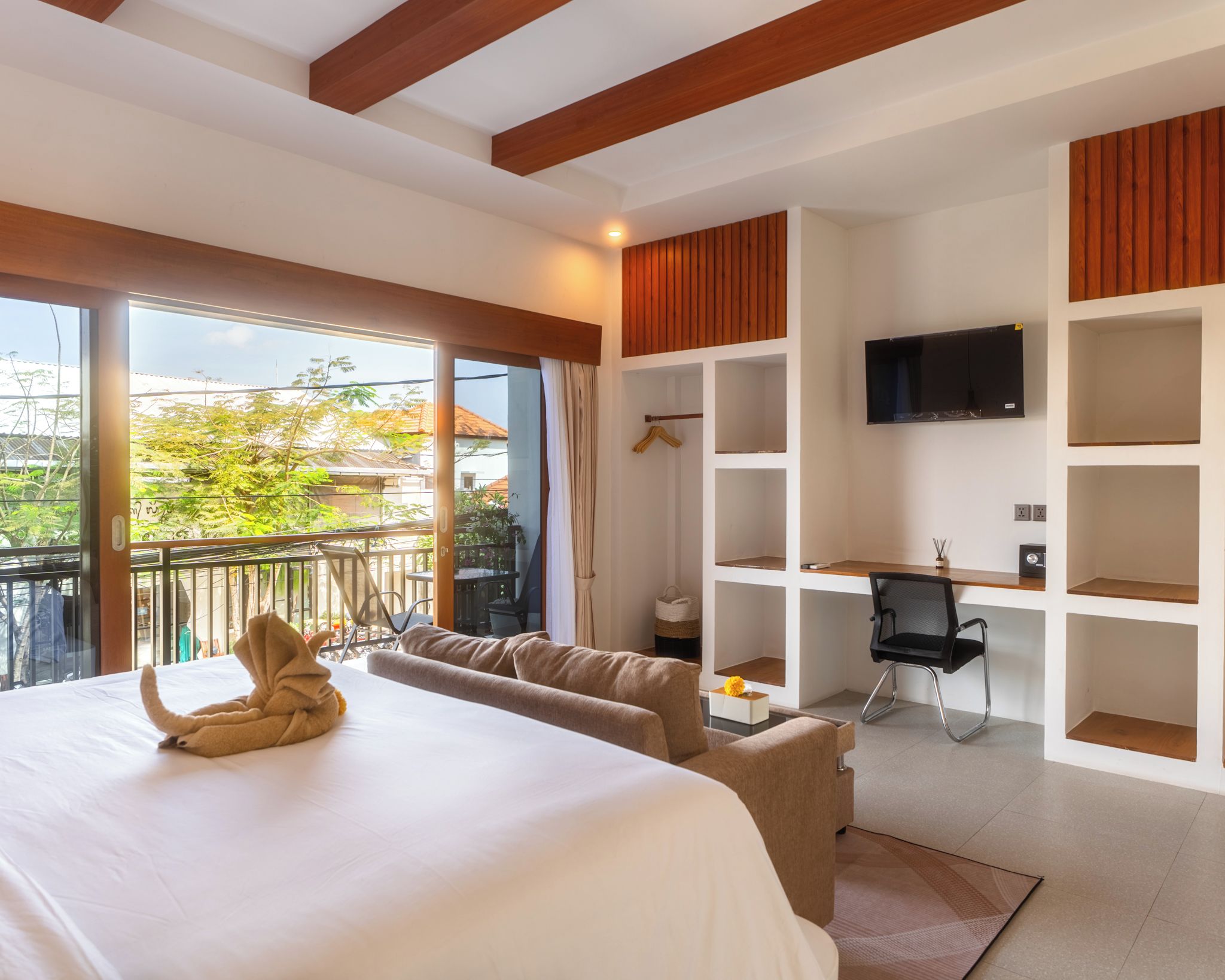 Una habitación de hotel con una cama, un escritorio, una silla y un televisor.