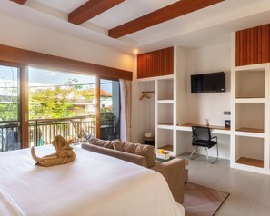 Una habitación de hotel con una cama, un escritorio, una silla y un televisor.