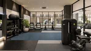 Une salle de sport équipée de tapis de course, d’appareils de musculation et d’une variété de poids.