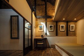 Un interior japonés tradicional con suelo de tatami, una mesa de madera baja y una silla.