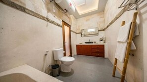 Une petite salle de bain comprenant des toilettes, un lavabo et une baignoire.