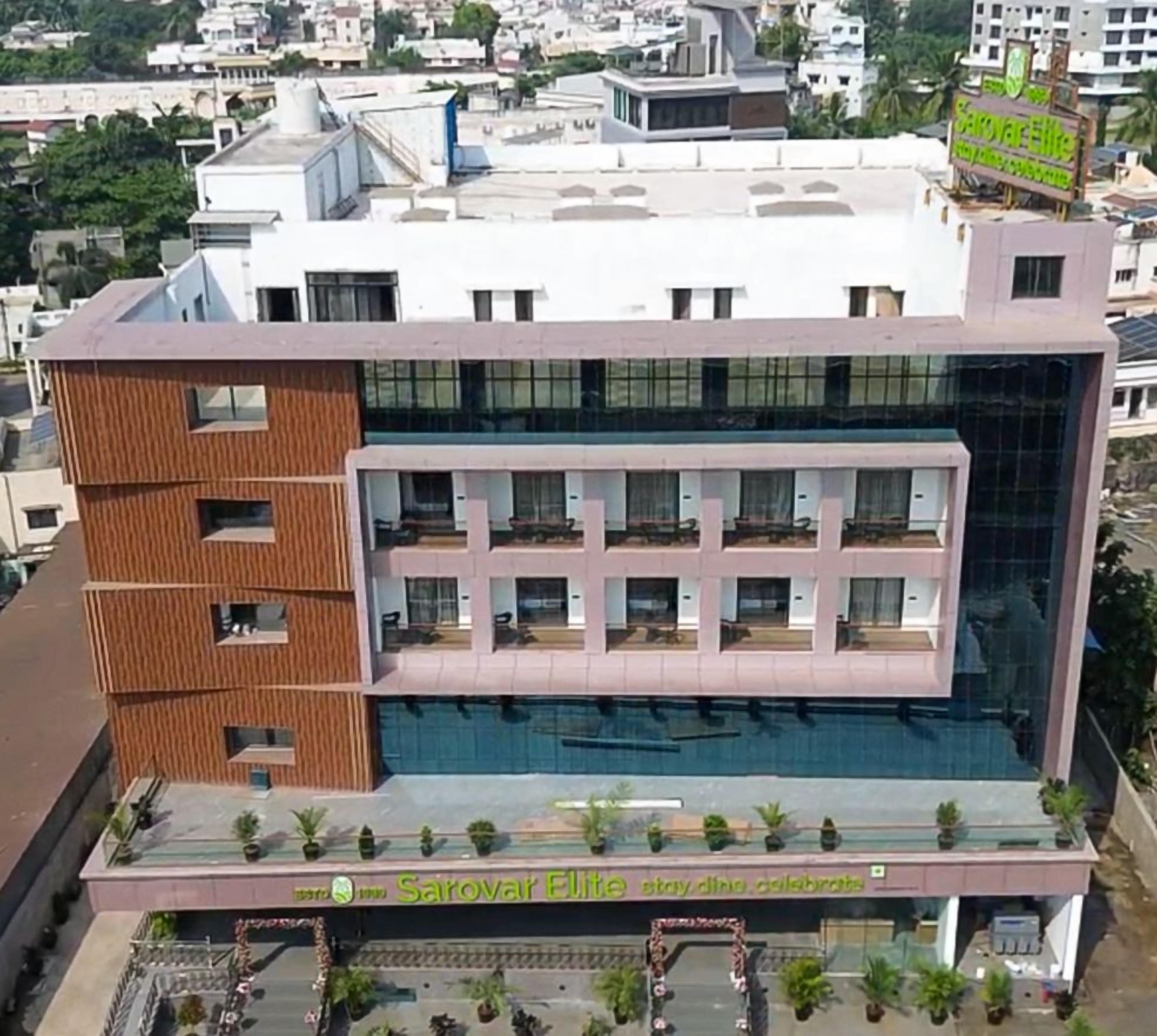 A modern building with a flat roof, multiple balconies, and a sign indicating a restaurant.