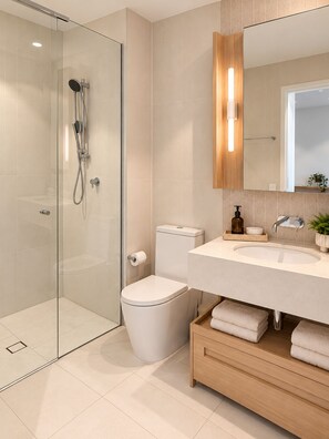 Een moderne badkamer met een douchecabine van glas, een toilet, een wastafel met spiegel en een houten wastafelmeubel.