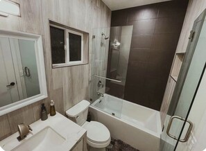 Une salle de bain moderne équipée d’une douche, de toilettes et d’un lavabo.