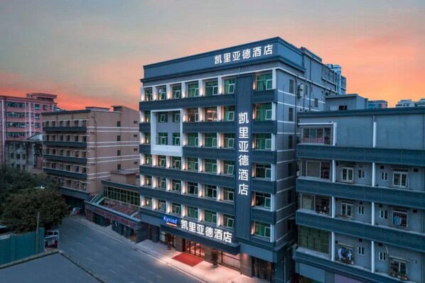 A multi-story hotel with a modern facade, featuring a prominent signage for '凯里亚德酒店' (Kairaiya De Hotel). - Kyriad Hotel (Shenzhen)