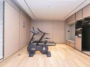 Une pièce moderne avec un plancher en bois, un vélo d’appartement et une petite plateforme pour les exercices de marche.