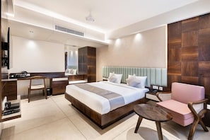 Habitació d'hotel moderna amb un llit gran, una taula de treball, una cadira i una televisió.