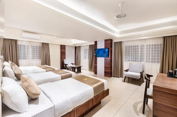 Habitació d'hotel amb dos llits, un televisor, una taula i una cadira.
